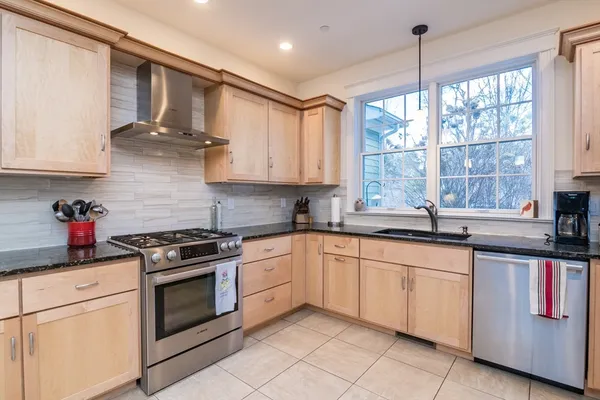 a kitchen with stainless steel appliances granite countertop a stove sink and cabinets
