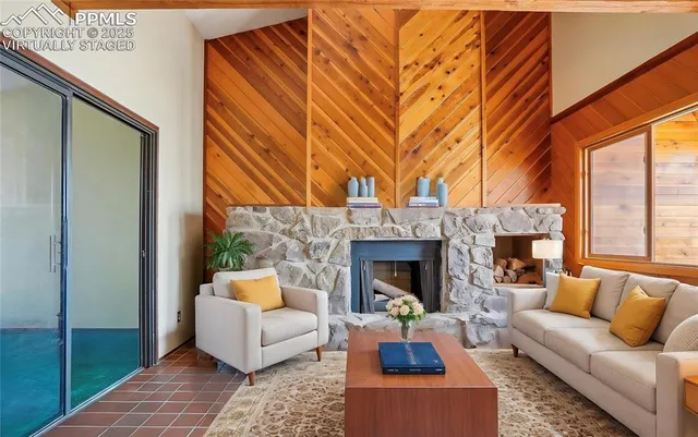 a living room with fireplace furniture and a rug