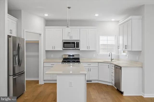 a kitchen with a sink stainless steel appliances and window