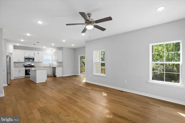 a view of an empty room with a fireplace and a window