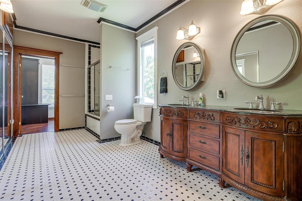 708 South Waco Street Weatherford, TX 76086 - Photo 15 of 35 a spacious bathroom with a granite countertop toilet a mirror and a shower