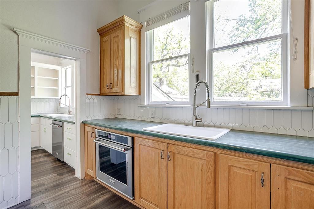 708 South Waco Street Weatherford, TX 76086 - Photo 22 of 35 a kitchen with granite countertop white cabinets and a window