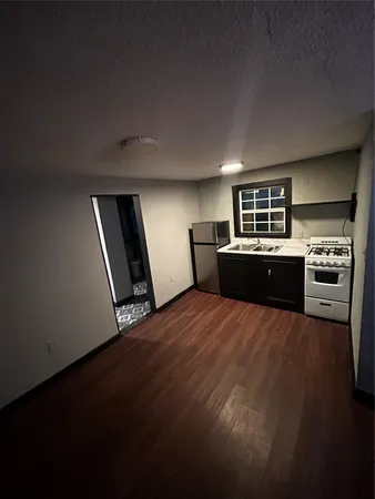 a kitchen with granite countertop a refrigerator and a stove top oven