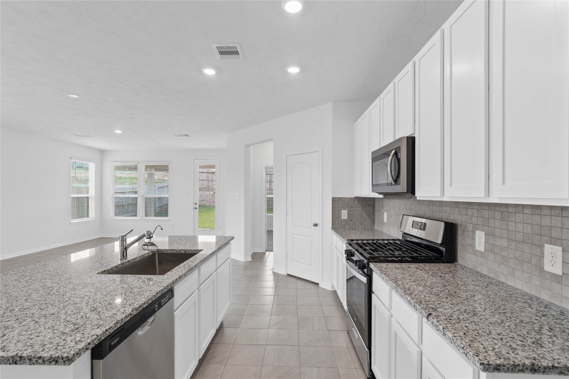 833 Mustang Rdg Terrace Magnolia, TX 77354 - Photo 8 of 21 a kitchen with stainless steel appliances granite countertop a sink stove and cabinets