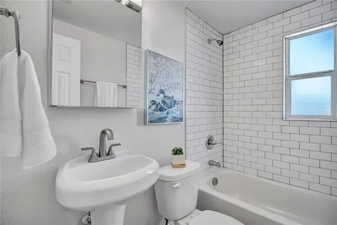 a bathroom with a sink a toilet and bathtub