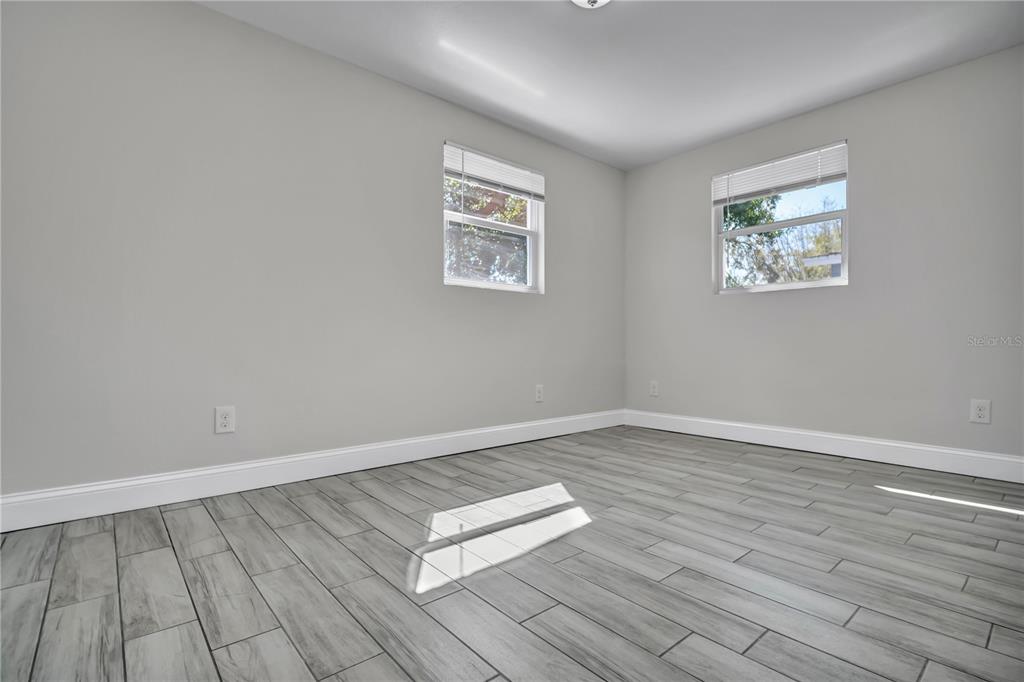6510 West Chelsea Street Tampa, FL 33634 - Photo 12 of 20 a view of an empty room with wooden floor and a window