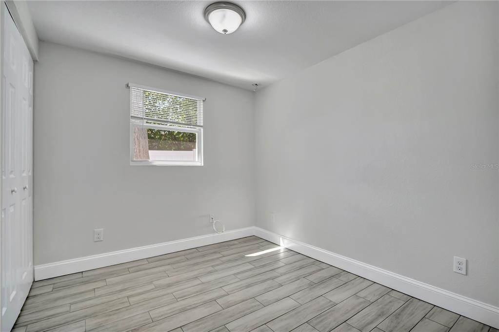 6510 West Chelsea Street Tampa, FL 33634 - Photo 13 of 20 a view of an empty room with wooden floor and a window