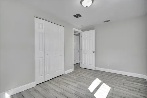 a view of empty room with wooden floor