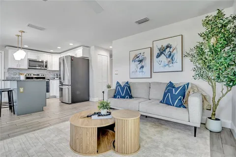a living room with furniture and a refrigerator