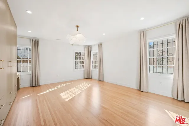 a view of a livingroom with wooden floor and a kitchen