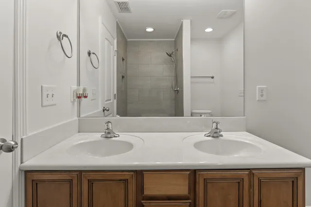 a bathroom with a granite countertop toilet and a shower