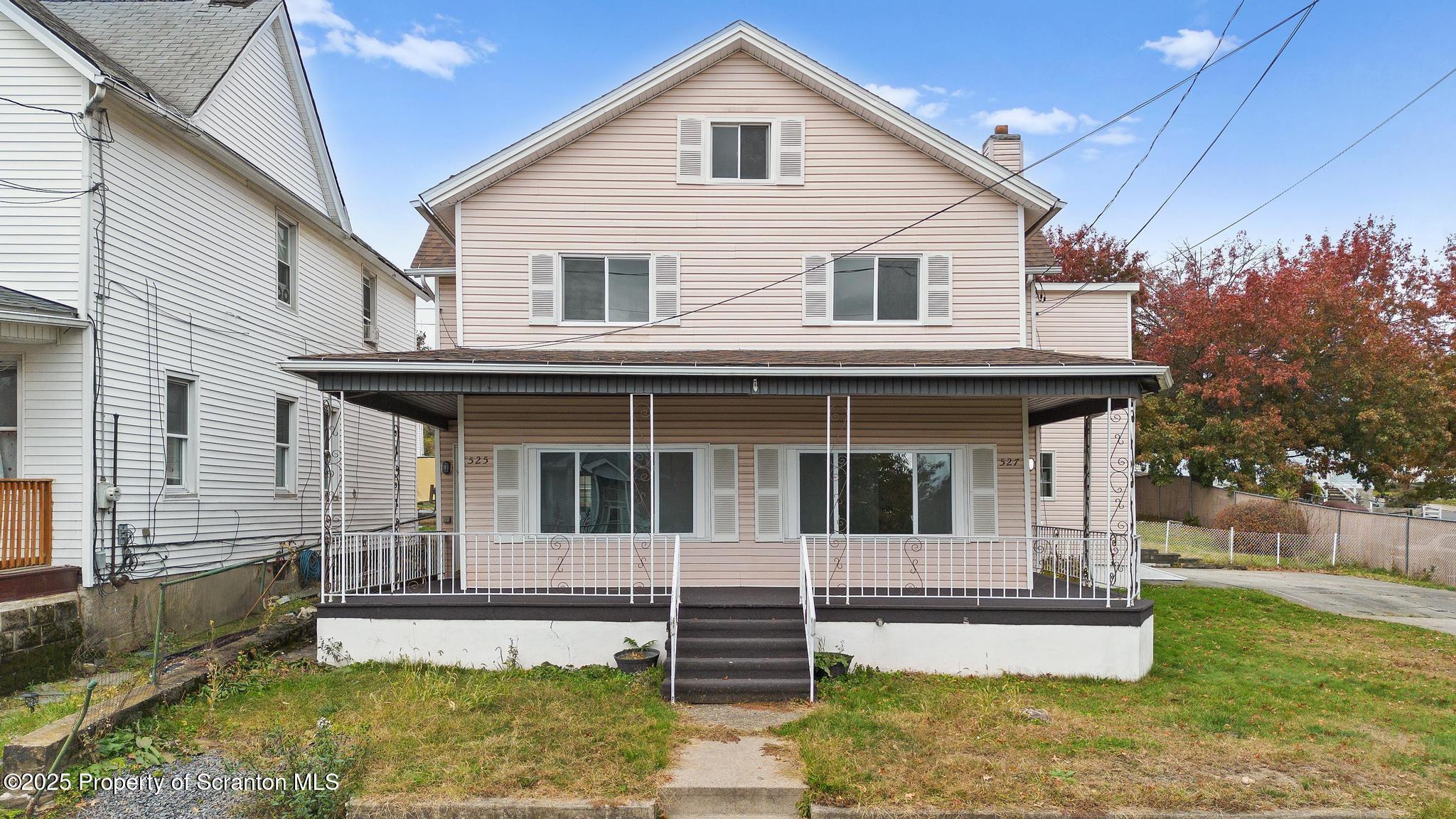 a view of a white house with large windows and a small yard