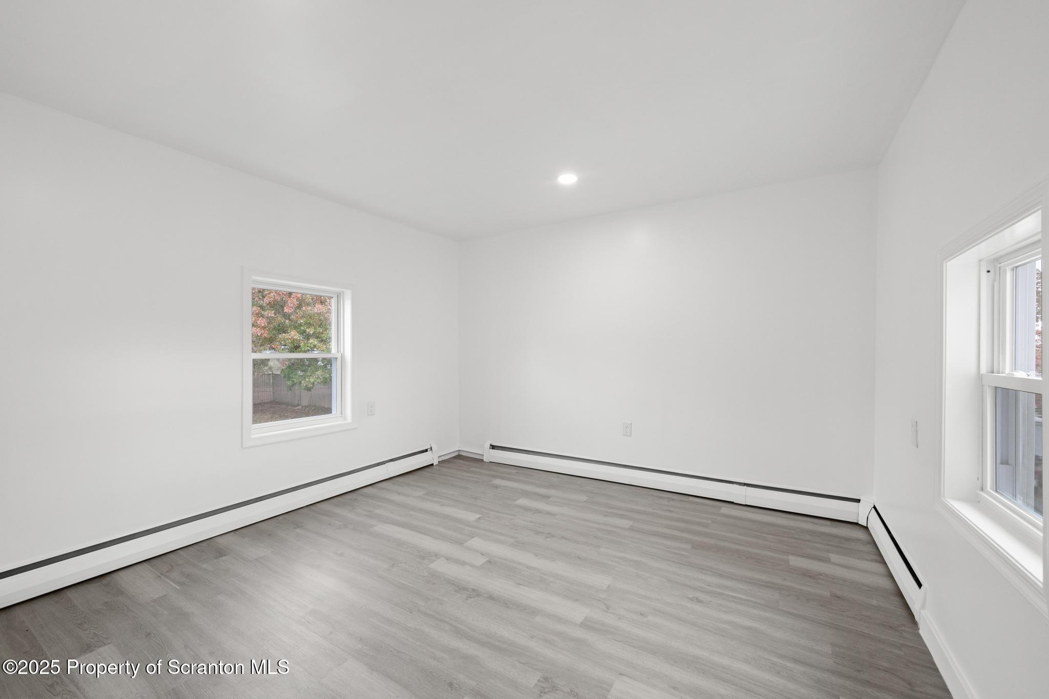 527 St Frances Cabrini Avenue, Unit 2 Scranton, PA 18504 - Photo 18 of 36 an empty room with wooden floor and windows