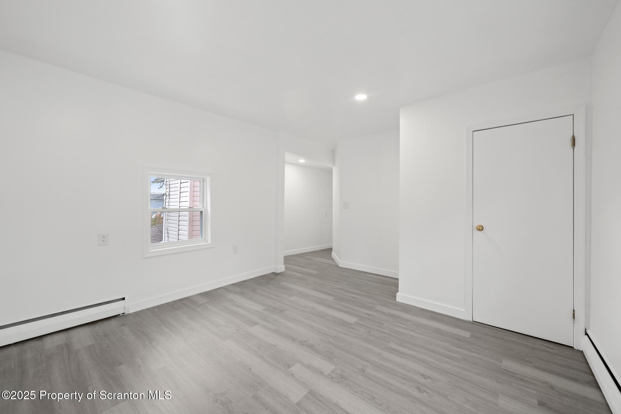 527 St Frances Cabrini Avenue, Unit 2 Scranton, PA 18504 - Photo 19 of 36 an empty room with wooden floor and windows