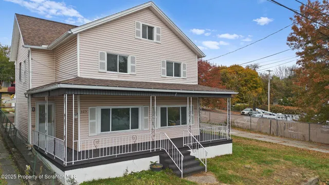 a view of house with a yard and wooden fence