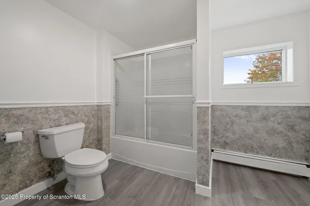 a bathroom with a toilet and a shower