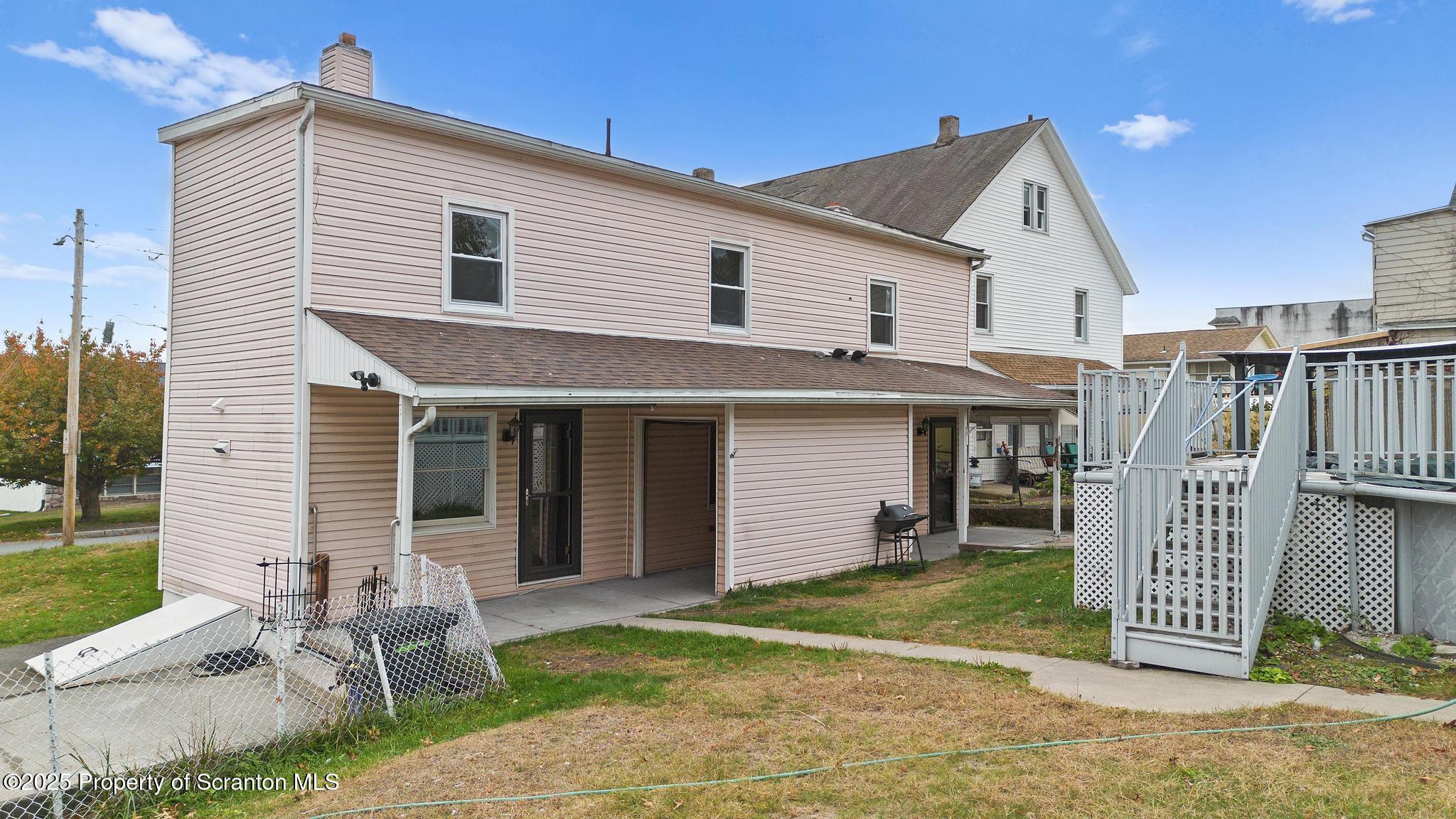527 St Frances Cabrini Avenue, Unit 2 Scranton, PA 18504 - Photo 32 of 36 a view of a white house with a small yard and a large window