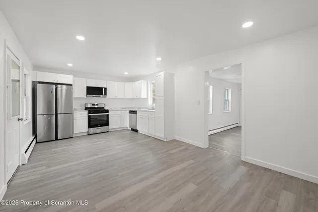 a view of kitchen with stainless steel appliances refrigerator microwave and stove