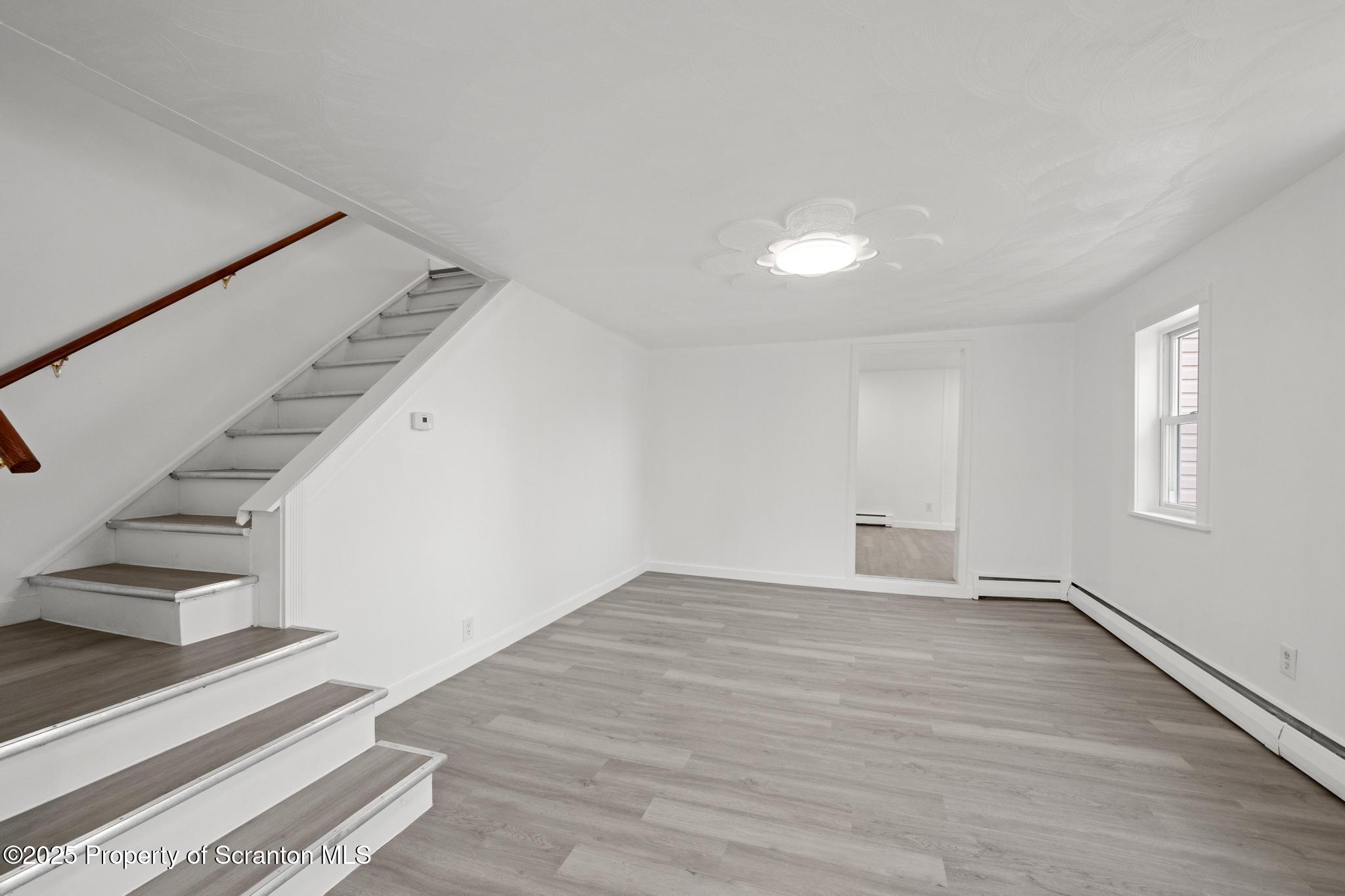 527 St Frances Cabrini Avenue, Unit 2 Scranton, PA 18504 - Photo 8 of 36 a view of an empty room with stairs and a ceiling fan