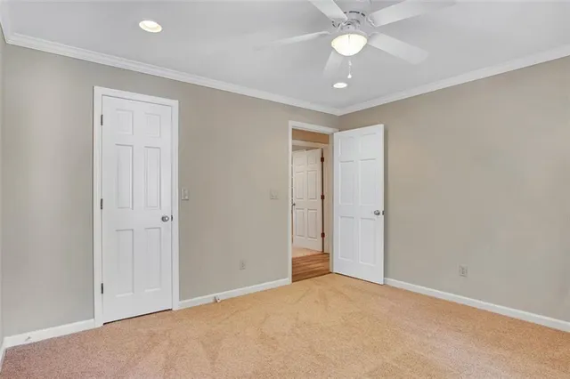 an empty room with closet and a ceiling fan