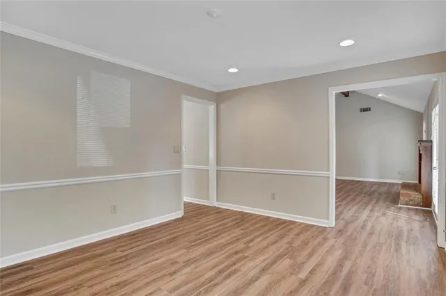a view of an empty room with wooden floor