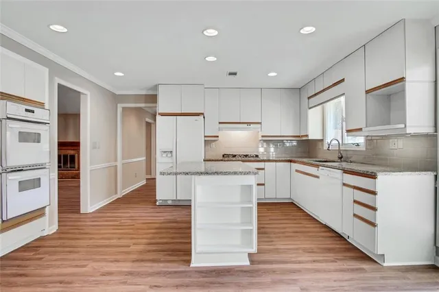 a kitchen with a refrigerator and white cabinets