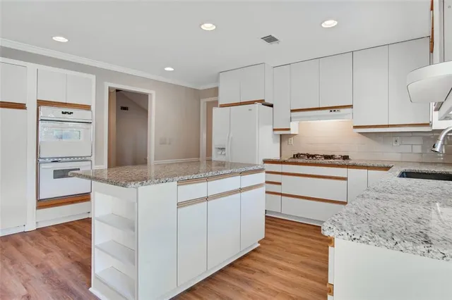 a kitchen with a refrigerator sink and cabinets