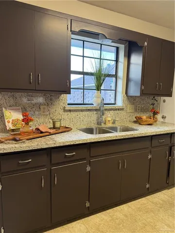 a kitchen with a sink a window and cabinets