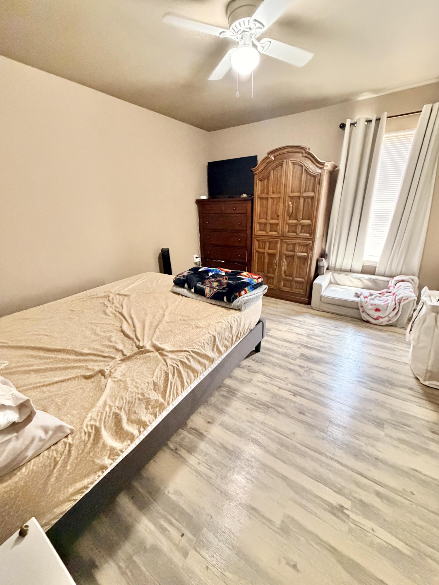 3211 East 5th Street Lubbock, TX 79403 - Photo 7 of 11 a view of a bedroom with wooden floor and window