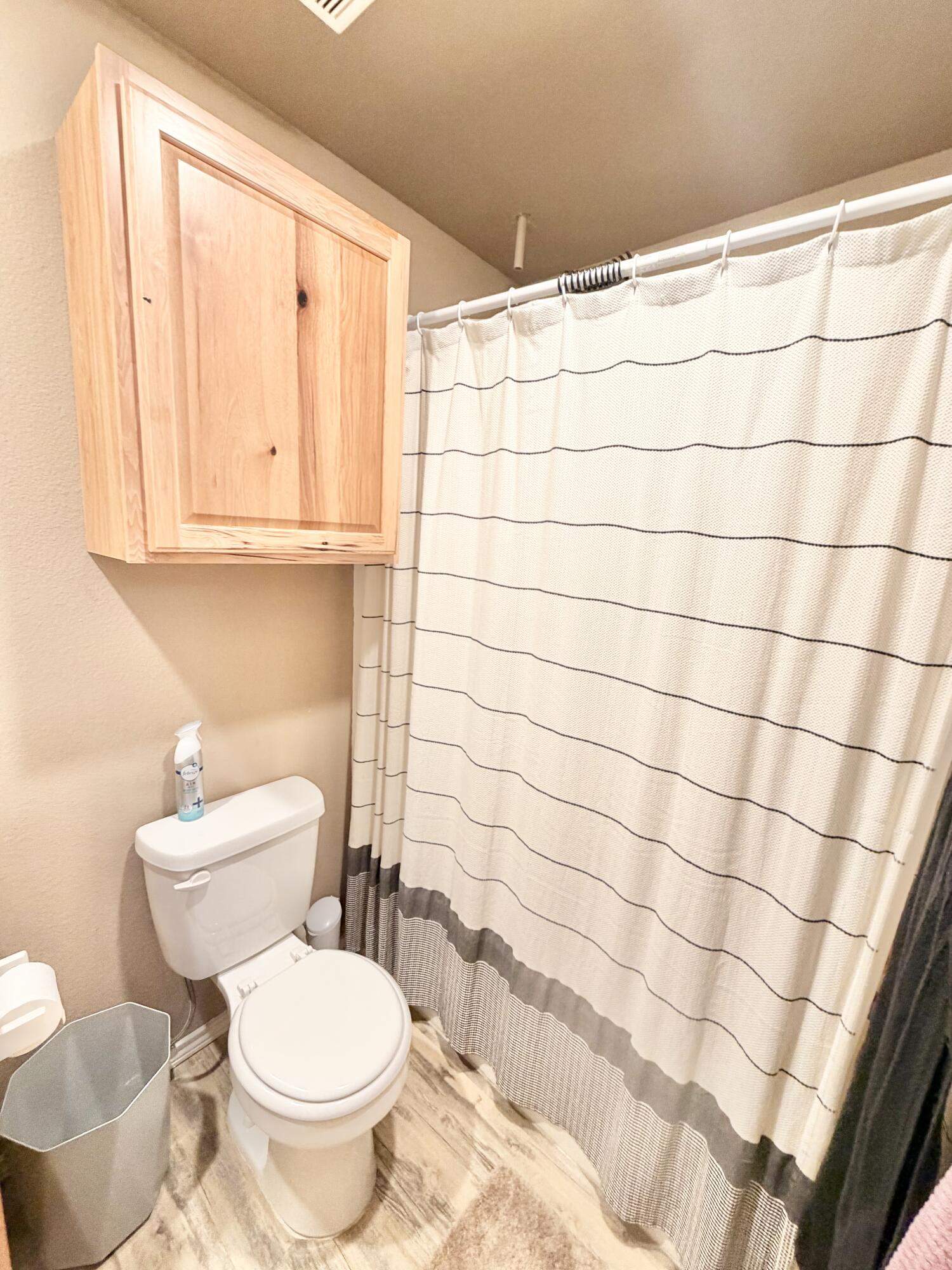 3211 East 5th Street Lubbock, TX 79403 - Photo 10 of 11 a bathroom with a toilet and a shower curtain