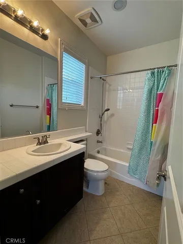 an empty room with windows and a ceiling fan