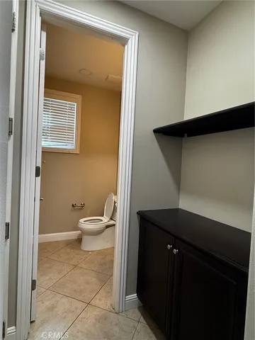 a bathroom with a granite countertop sink and a toilet