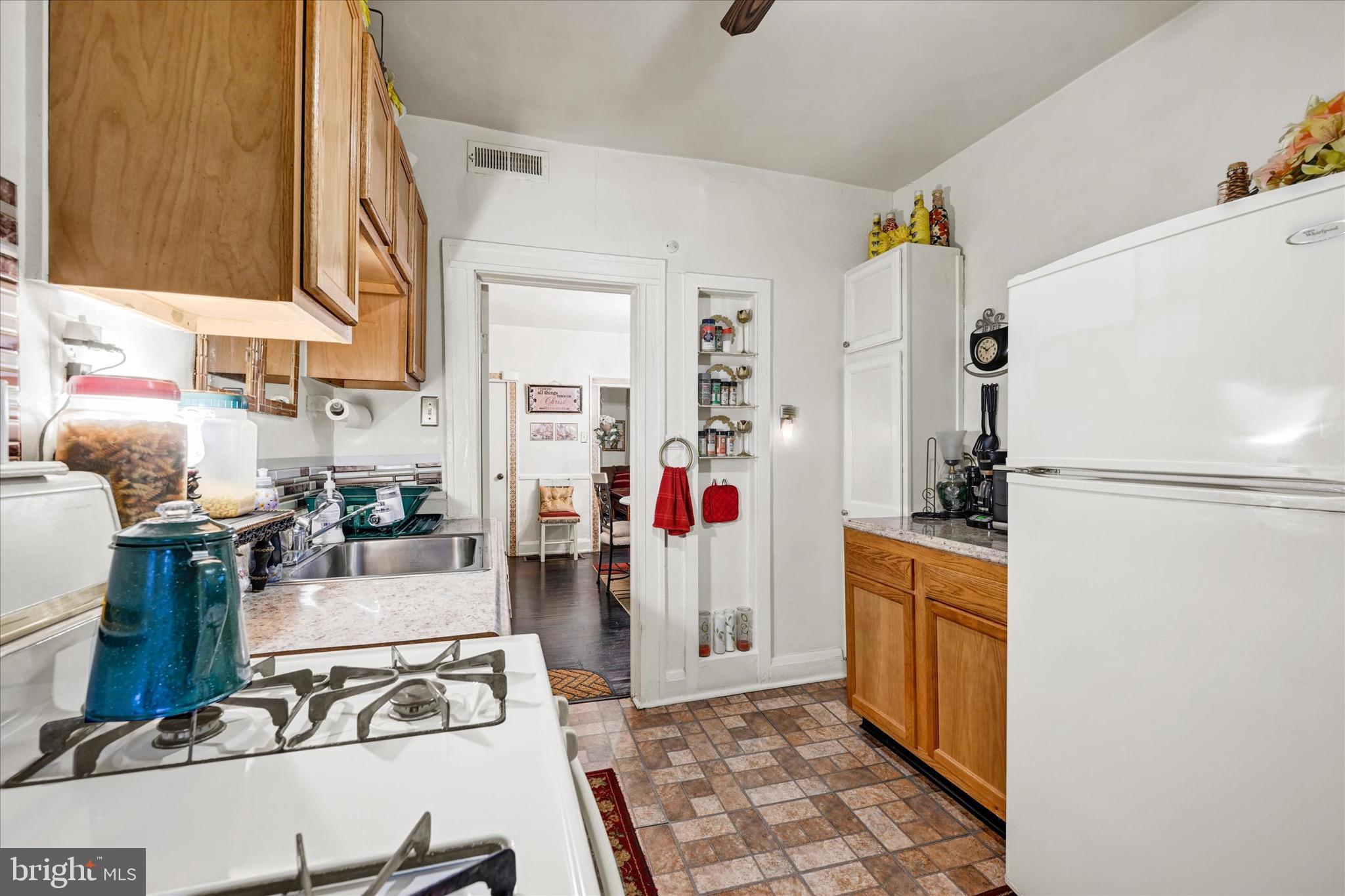 48 North Ellamont Street Baltimore, MD 21229 - Photo 12 of 26 a kitchen with stainless steel appliances granite countertop a refrigerator and a stove