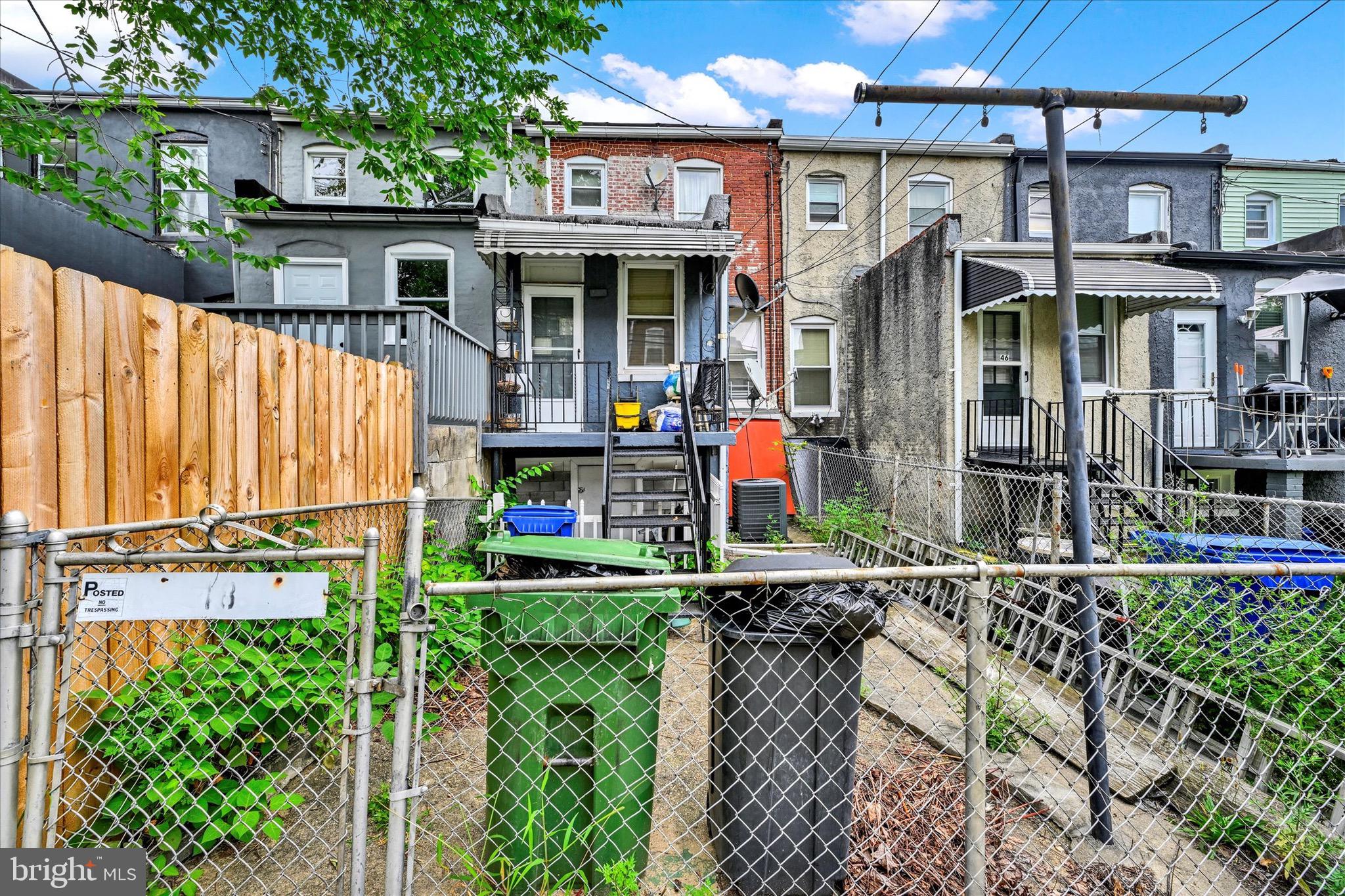 48 North Ellamont Street Baltimore, MD 21229 - Photo 25 of 26 a view of a house with a small yard and wooden fence