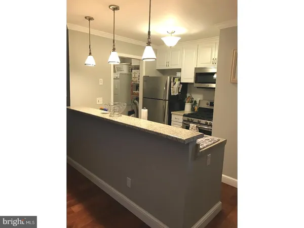 a kitchen with a sink a refrigerator and chairs