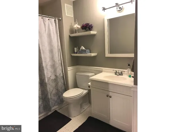 a bathroom with a sink toilet and a mirror