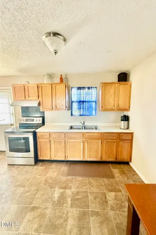 a kitchen with stainless steel appliances a stove a sink and a refrigerator