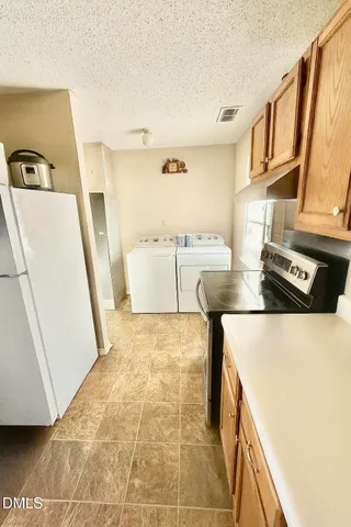 a kitchen with a refrigerator a stove top oven and a counter top space