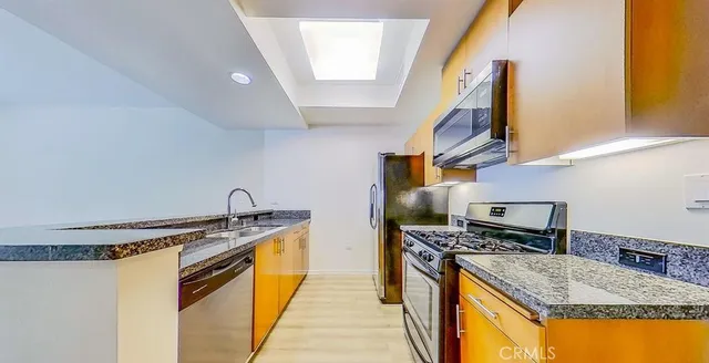 a kitchen with stainless steel appliances granite countertop a sink stove and refrigerator