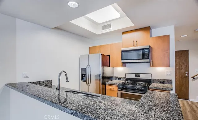 a kitchen with granite countertop a sink and a stove