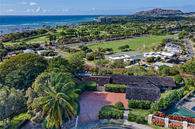 an aerial view of a city with lots of residential buildings ocean and mountain view in back