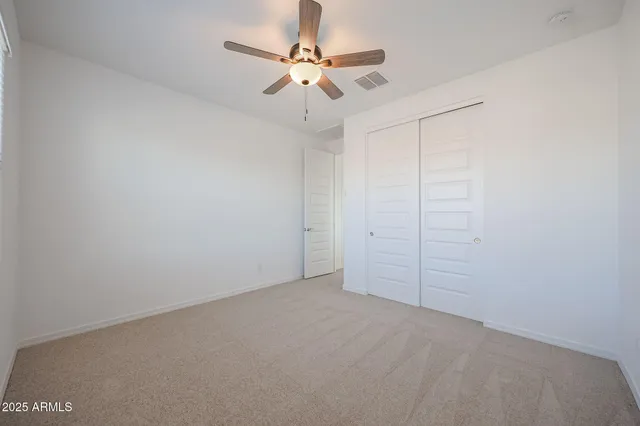 an empty room with a ceiling fan and a window