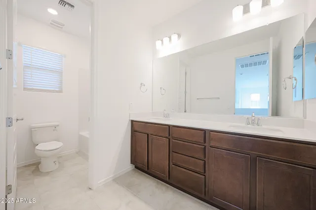 a bathroom with a double vanity sink and a toilet