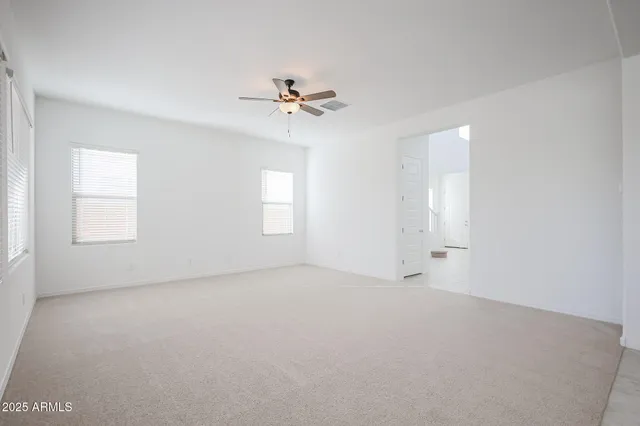 an empty room with windows and fan