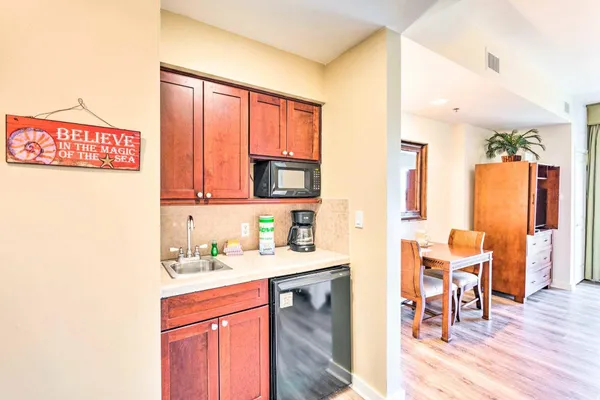 a kitchen with a sink cabinets and wooden floor