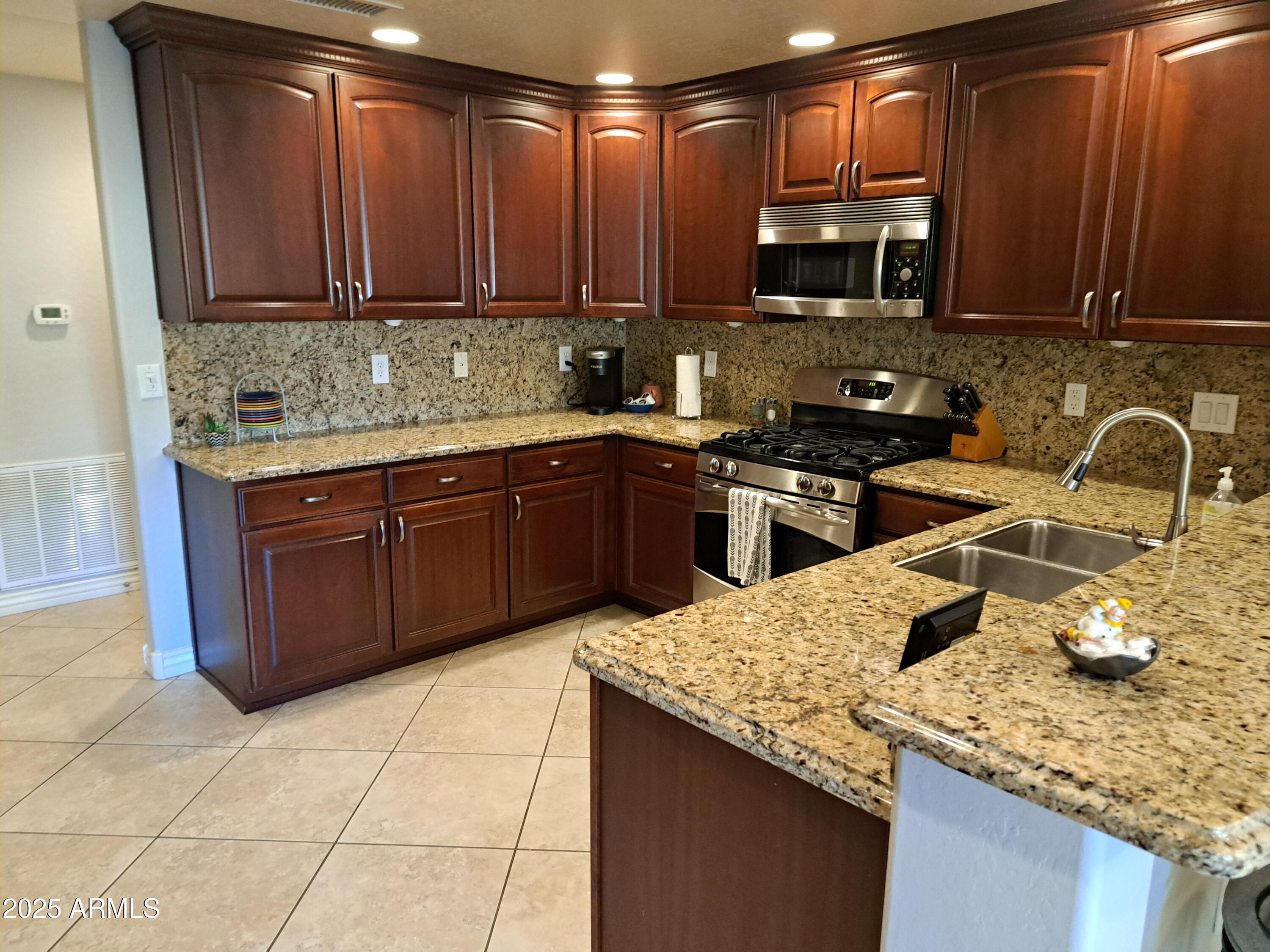 21320 North 56th Street, Unit 1163 Phoenix, AZ 85054 - Photo 13 of 48 a kitchen with stainless steel appliances granite countertop a sink stove and refrigerator
