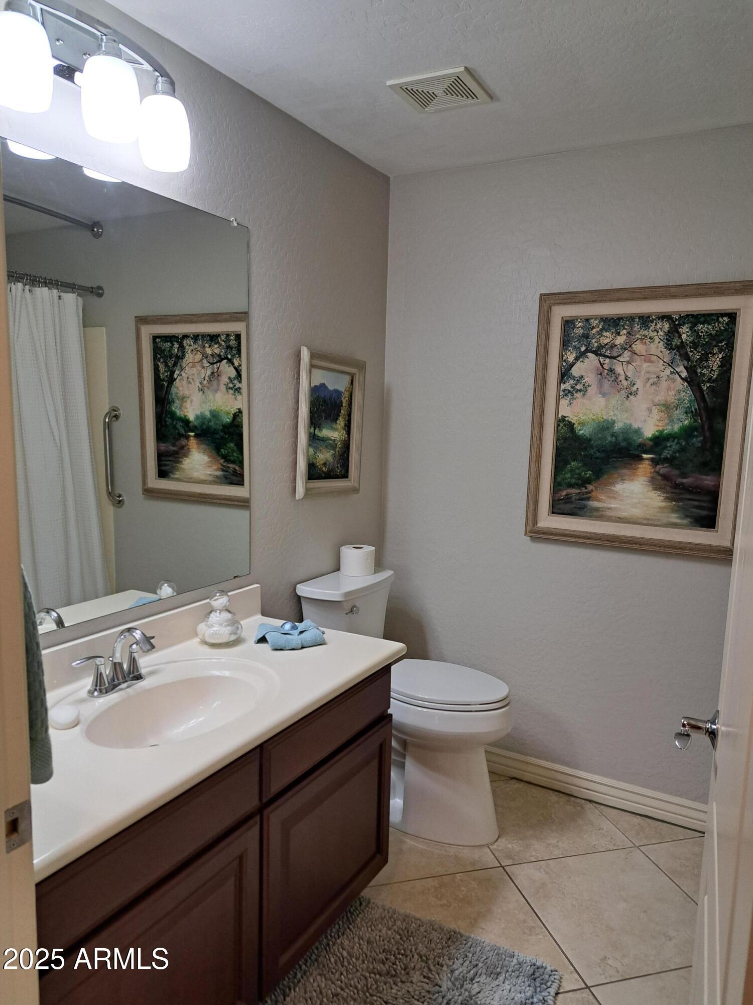 21320 North 56th Street, Unit 1163 Phoenix, AZ 85054 - Photo 33 of 48 a bathroom with a toilet a sink and mirror