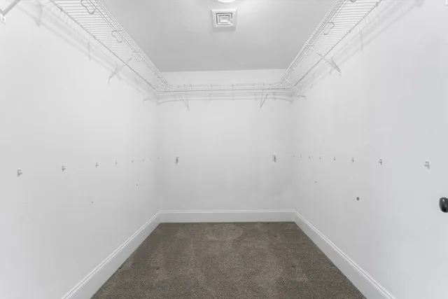 a bathroom with a granite countertop sink a toilet a mirror and a window