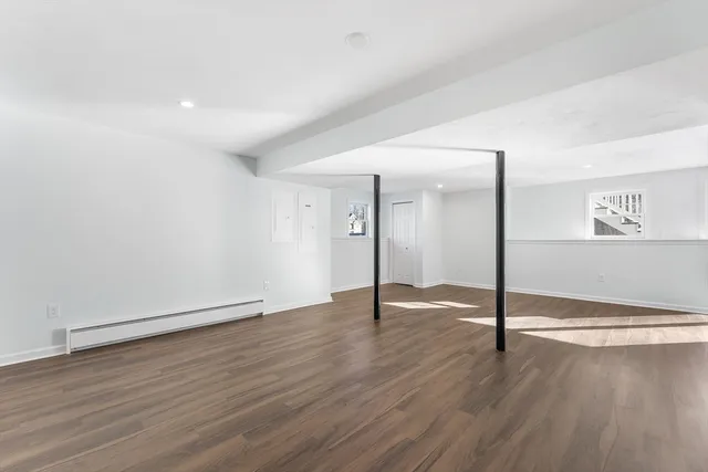 a view of an empty room with wooden floor