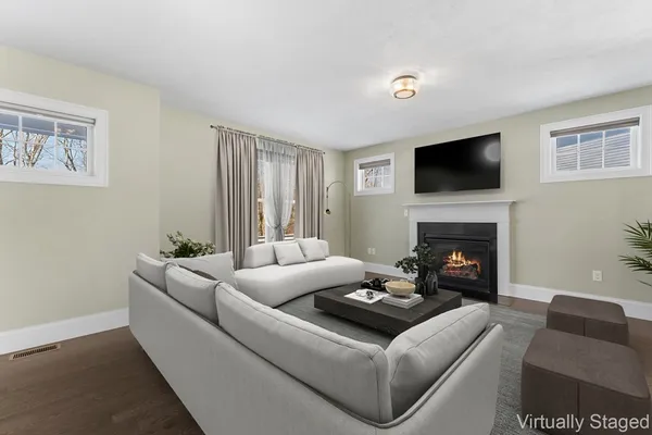 a living room with furniture a flat screen tv and a fireplace